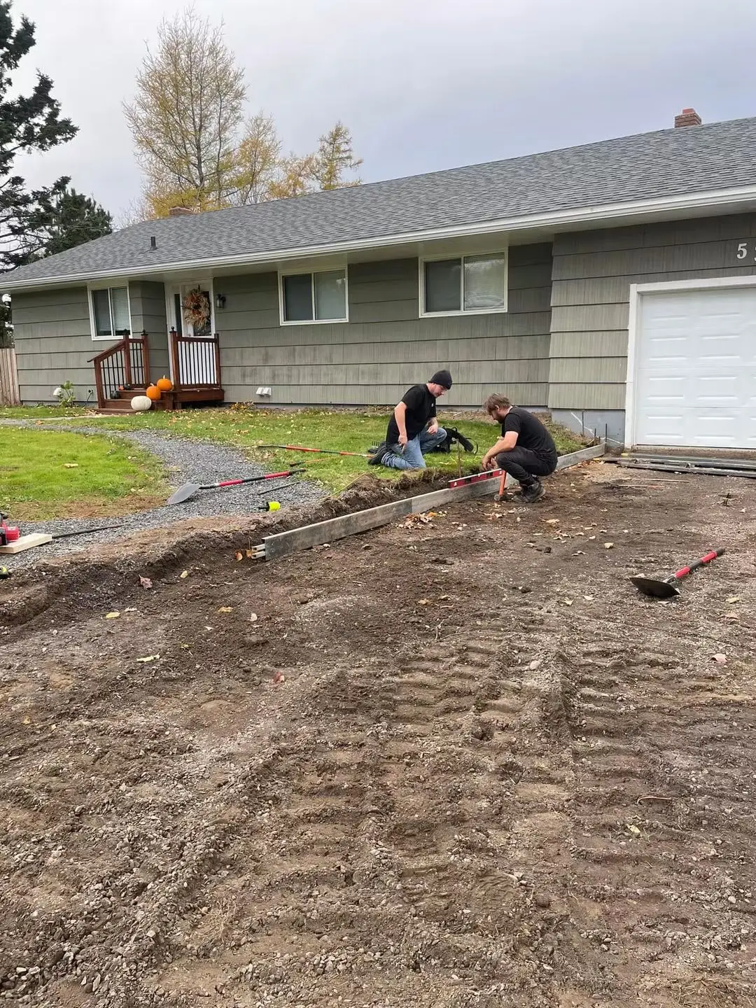 Langille crew digging out an old driveway in front of a bungalow