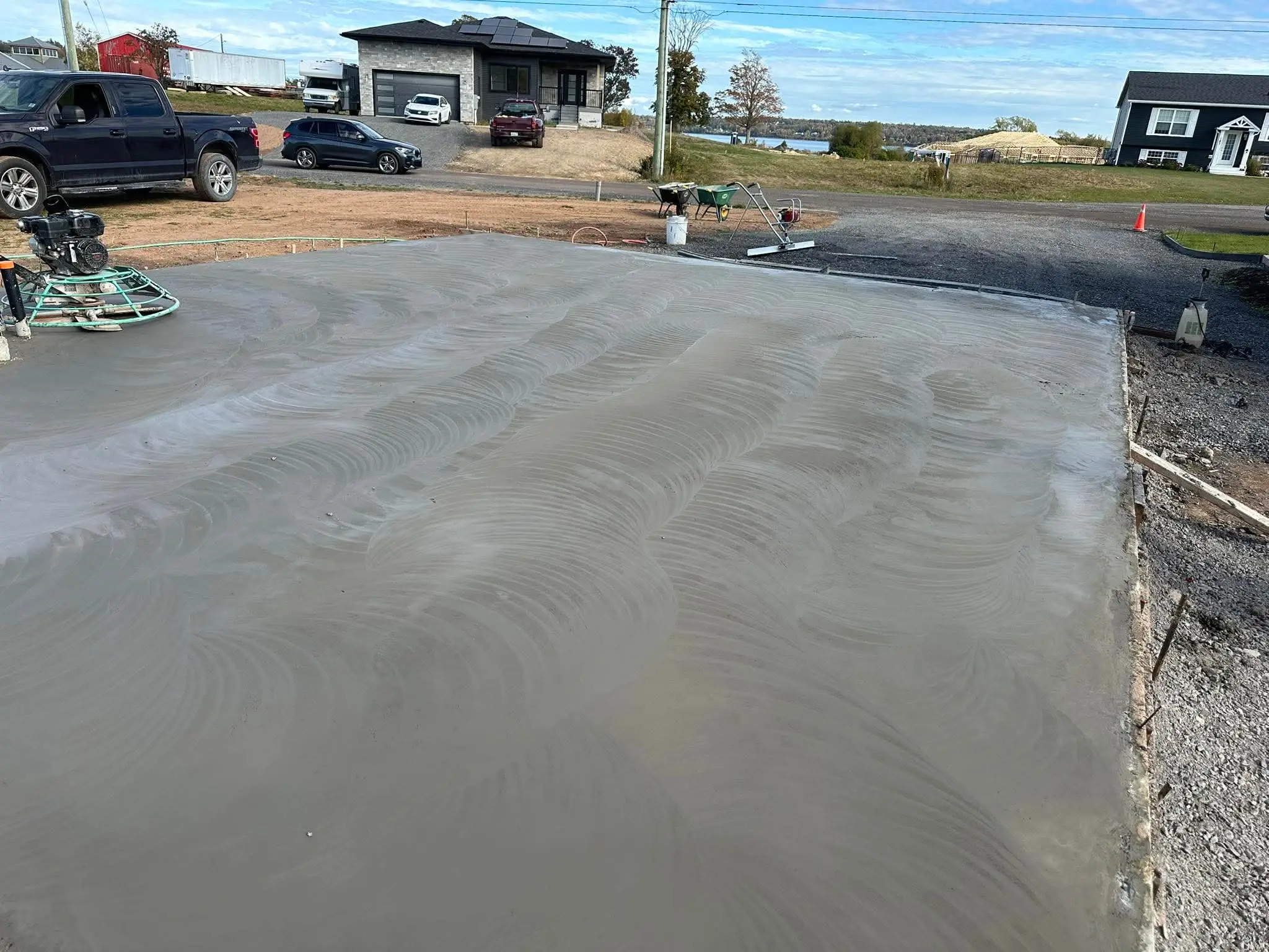 Large concrete pad being power-trowelled smooth, with the trowel machine on the edge