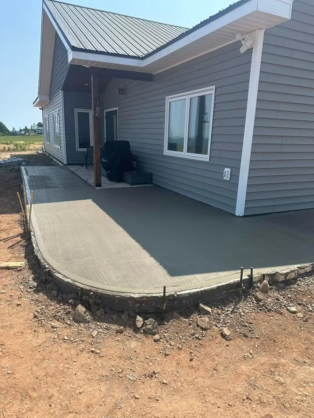 Finished curved patio along the side of a shoreline home