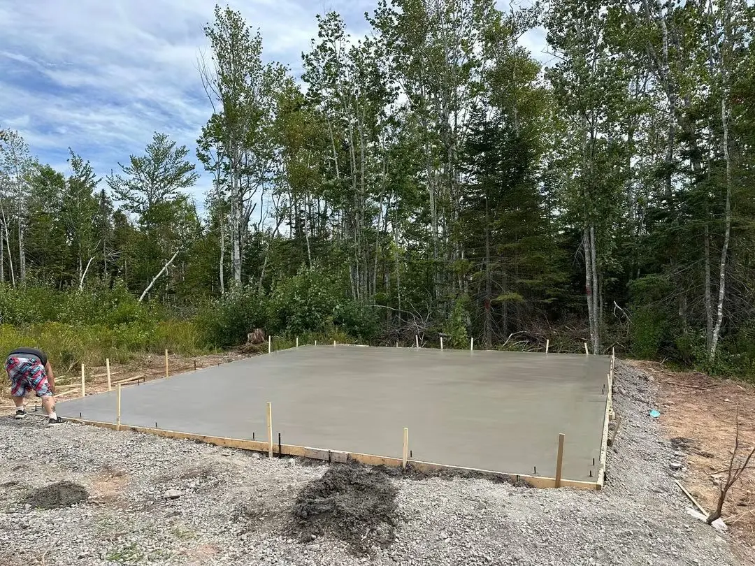 Concrete slab inside staked forms on a wooded building lot