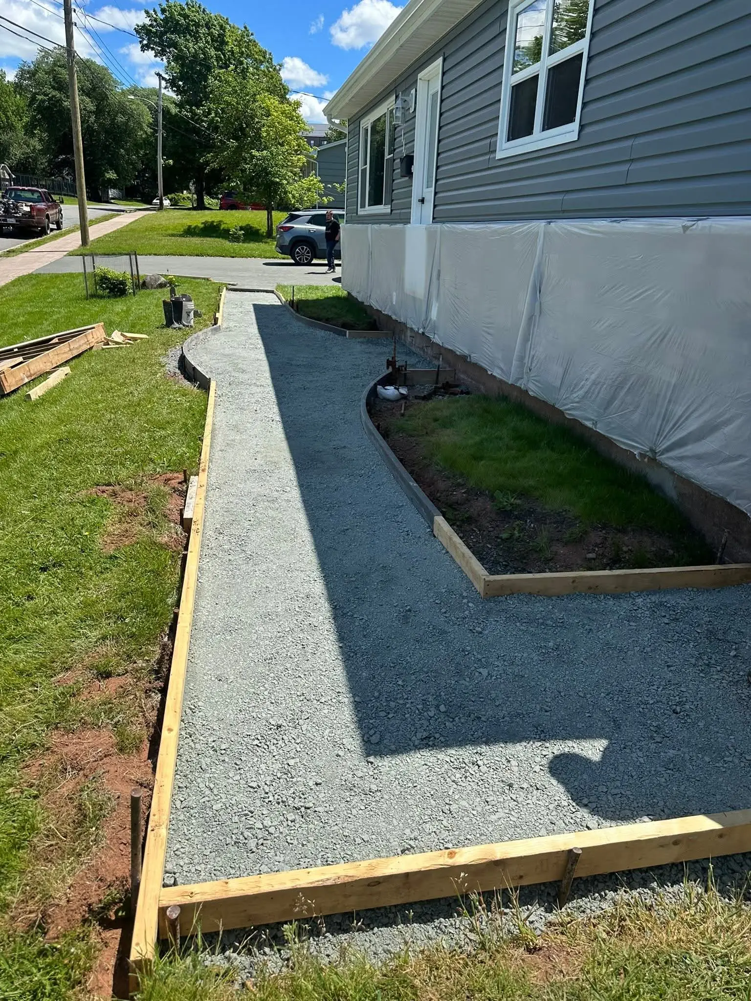 Compacted gravel base and wooden forms set for a new walkway