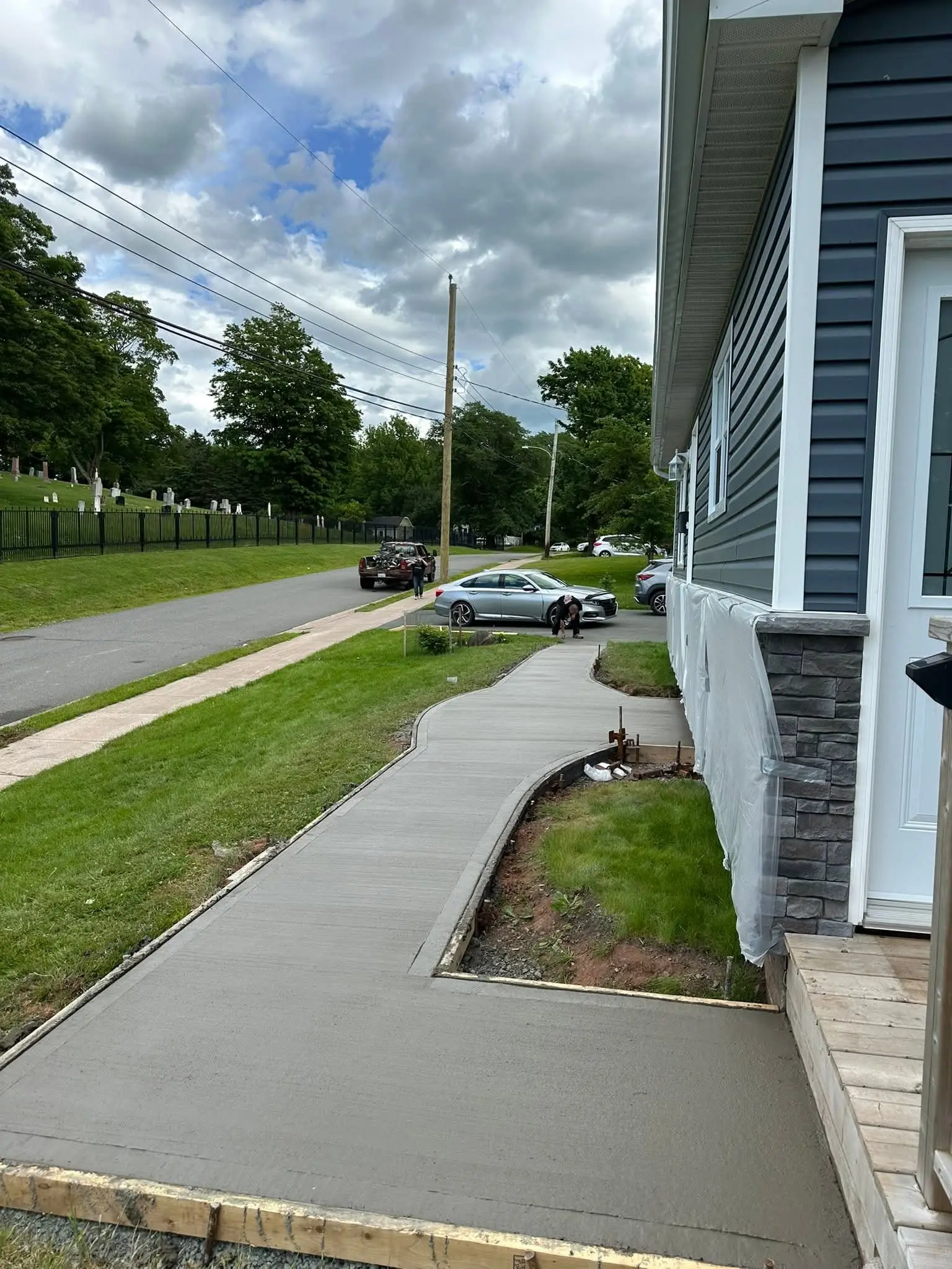 Curved front walkway poured beside a lawn and garden bed